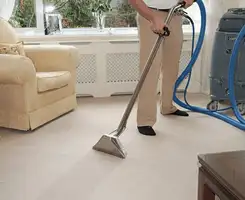 Carpet cleaning professional removing dirt and stains with a hot-water extraction tool in a home, Charlotte, NC.