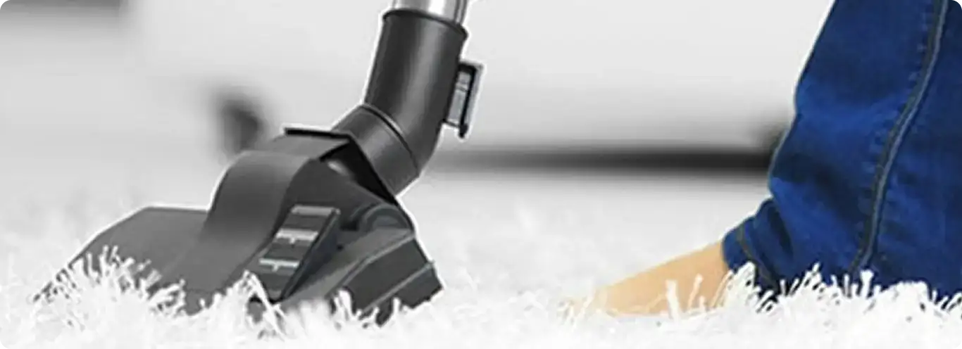 Close-up of a professional vacuuming a white carpet in Indian Trail.